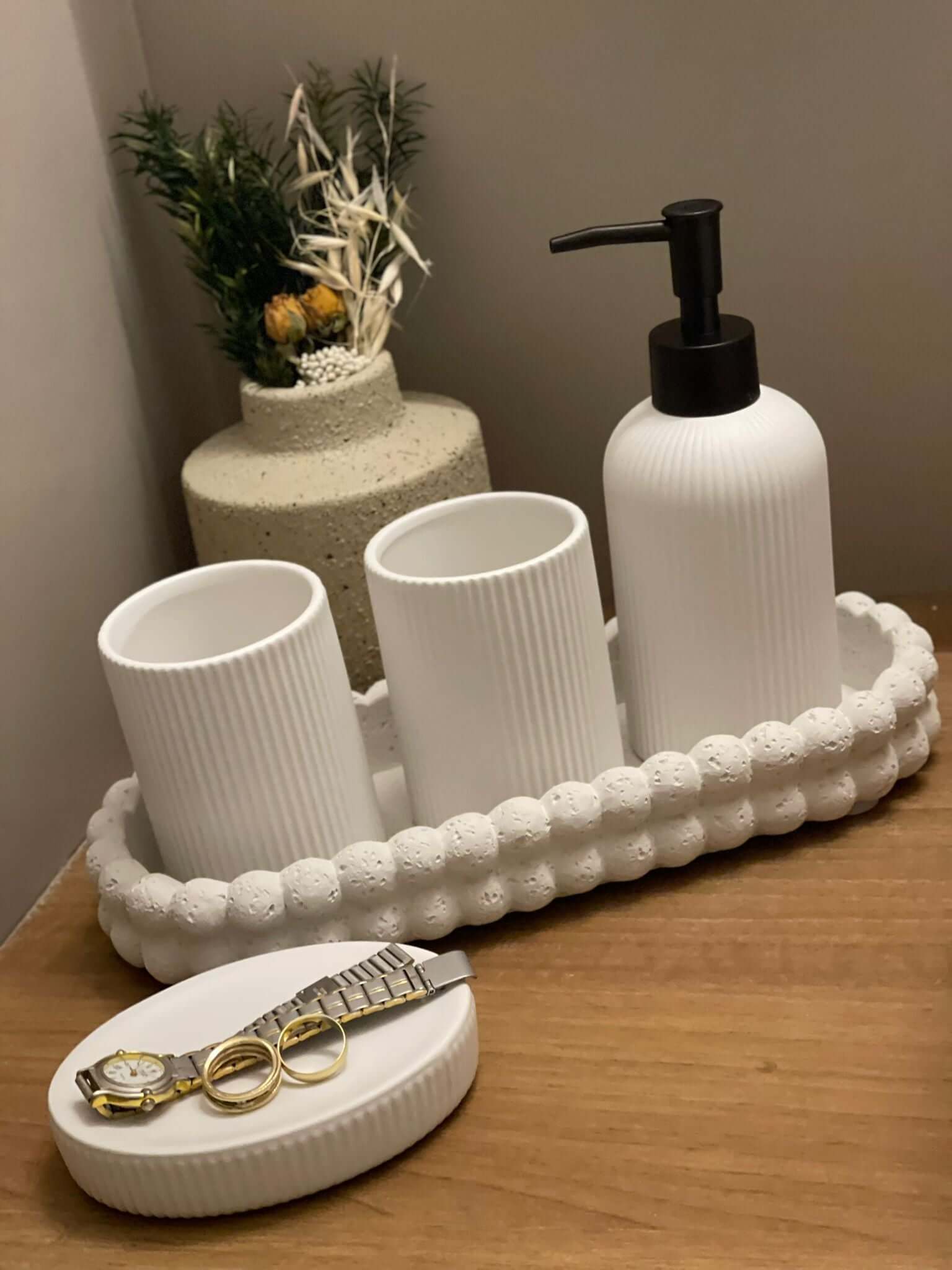 Elegant white ceramic bathroom set with striped design, includes soap dispenser, two toothbrush cups, and dish for jewelry or soap.