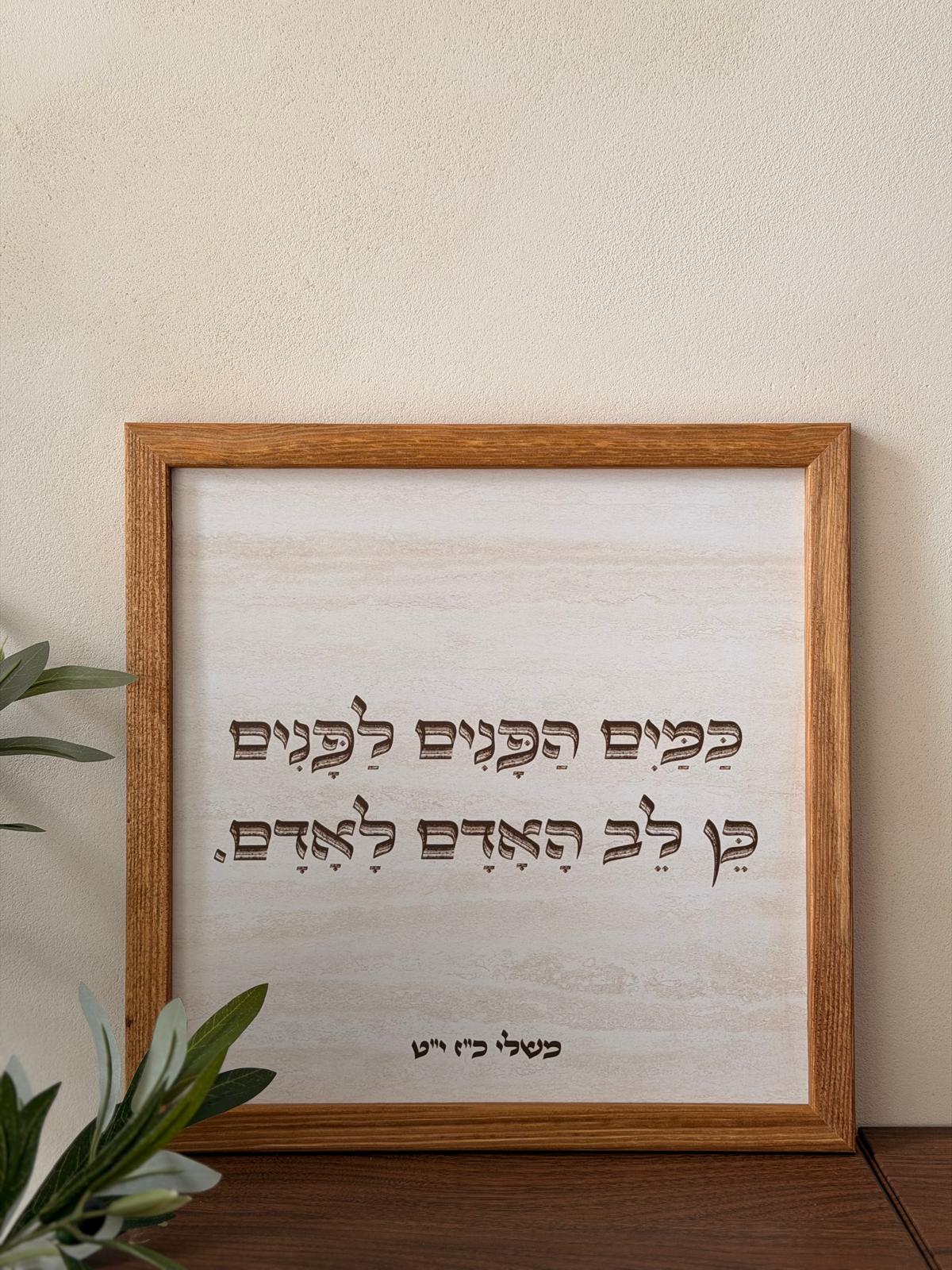 תמונה ממוסגרת במסגרת עץ אגוז 30*30 ס"מ עם רקע דמוי אבן טרוורטין והפסוק "כמים הפנים לפנים" בטיפוגרפיה ייחודית | 1item