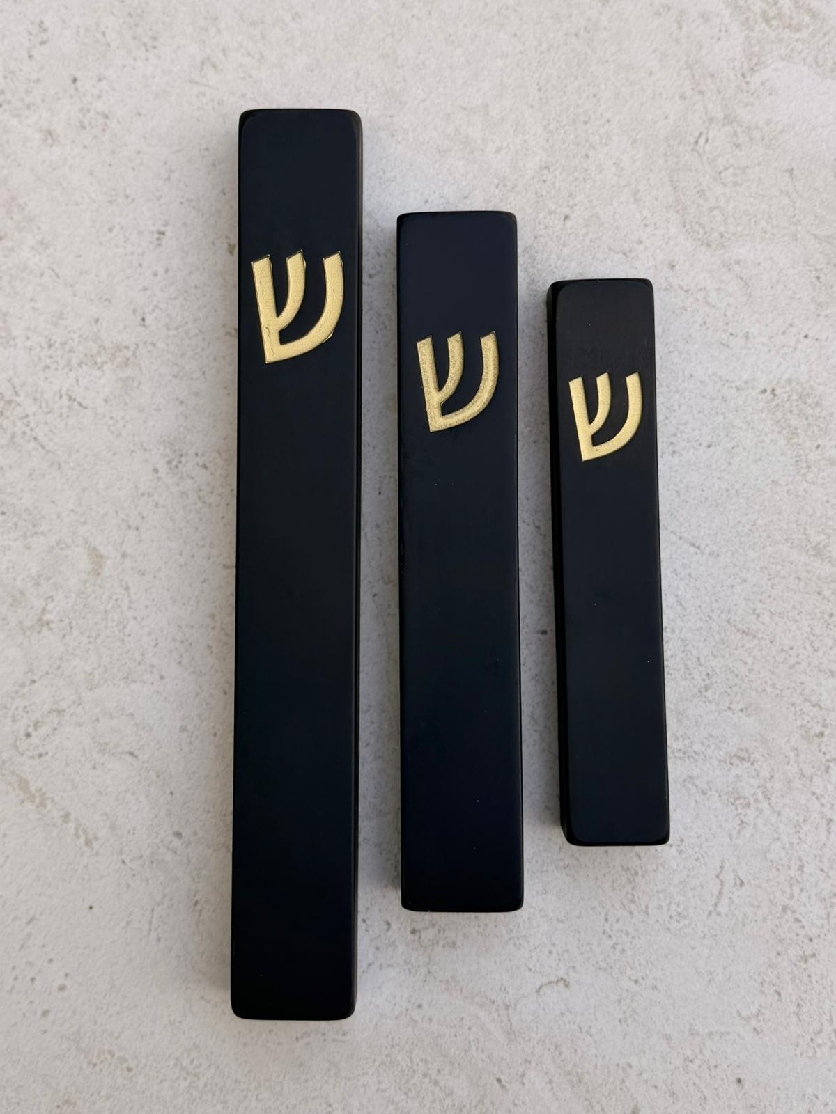 בית מזוזה מבטון שחור אוניקס בעיצוב מינימליסטי עם אות ש׳ בזהב, קיים במספר גדלים לבחירה