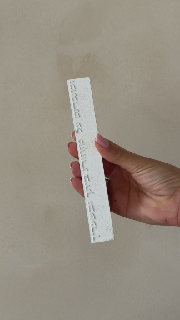 בית מזוזה לבן מחוספס עם כיתוב שמע ישראל אנכי בתבליט